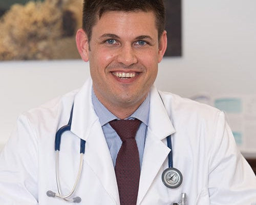 Portrait von Dr. Stefan Wöhrer im weissen Arztkittel und Stetoskop um den Hals.