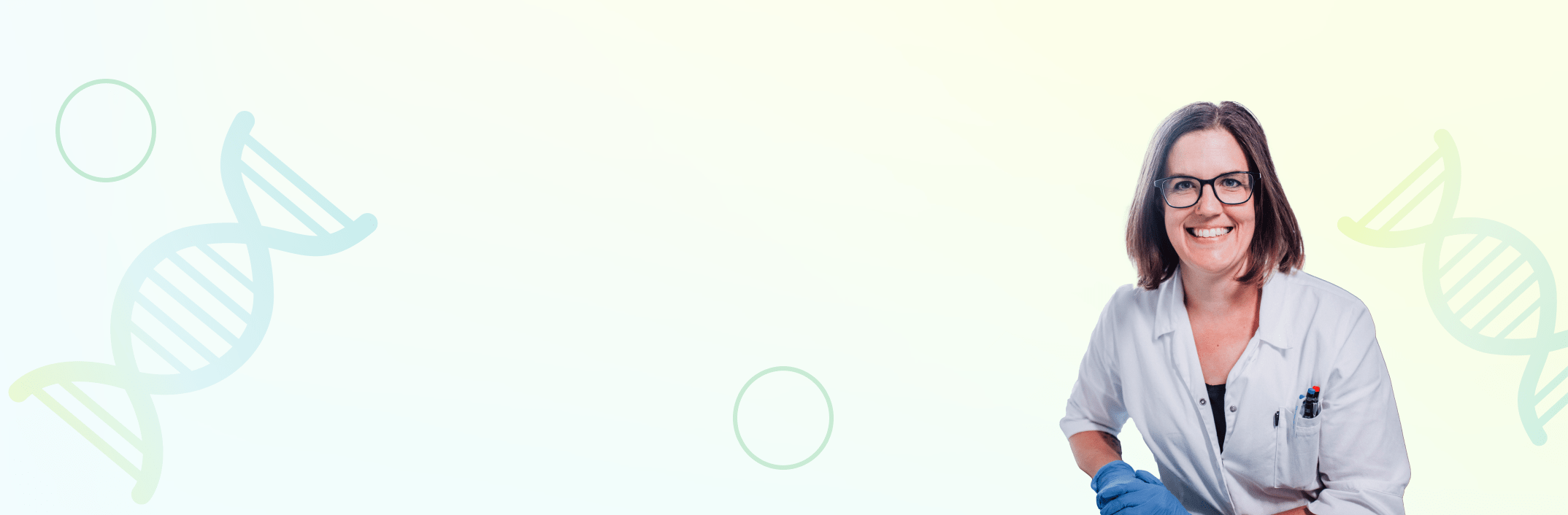 Laborangestellte im weissen Kittel und brauen Haaren lächelt.