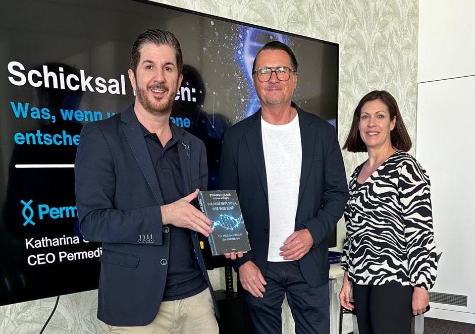 Taeuber Marcus Franz Gyoengyoesi und Katharina Schneider stehen zusammen und halten das Buch "Warum wir sind wie wir sind" von Dr. Huber und Dr. Wöhrer in der Hand